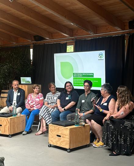 Menschen auf einem Podium diskutieren miteinander.